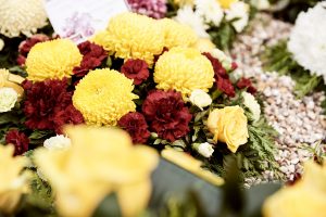 Funeral floral arrangement with yellow chrysanthemums and red carnations