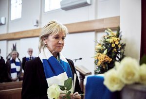 Woman attending funeral in football scarf