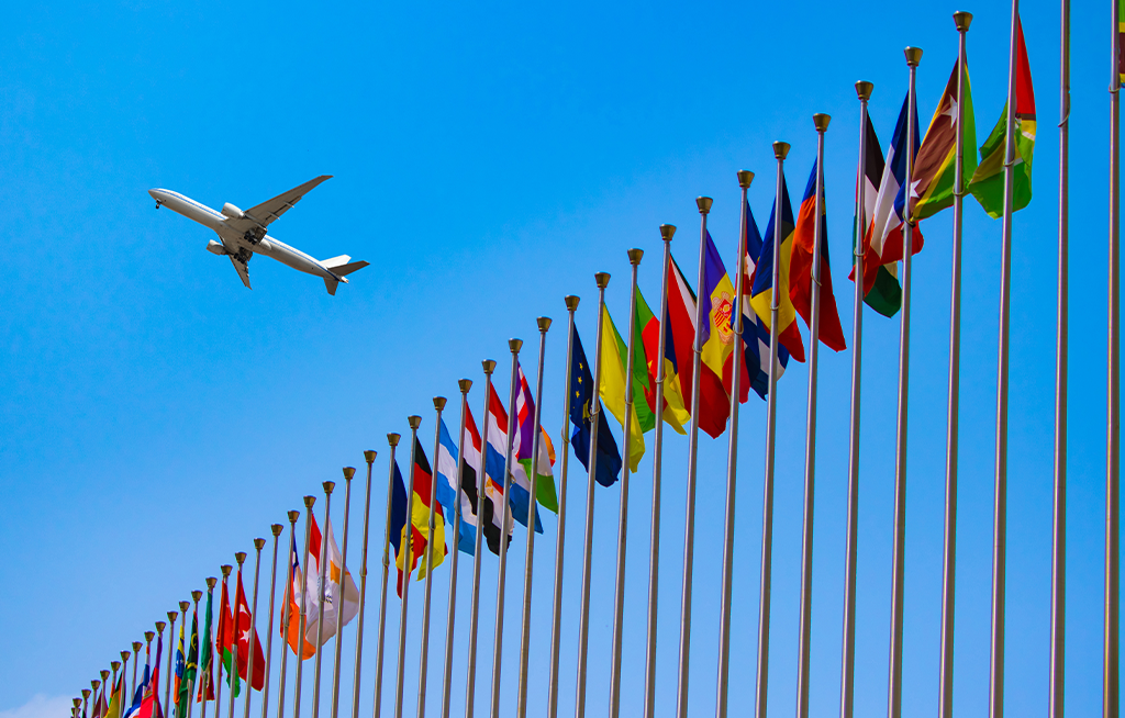 Airplane flying over international flags